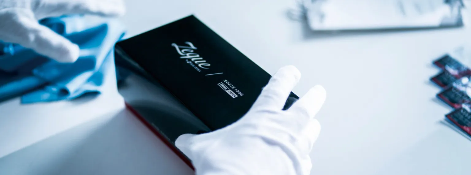 白手袋で Zeque の製品パッケージを扱う様子